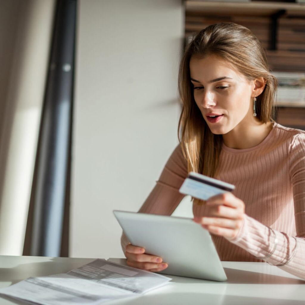 a woman holding a credit card on a tablet