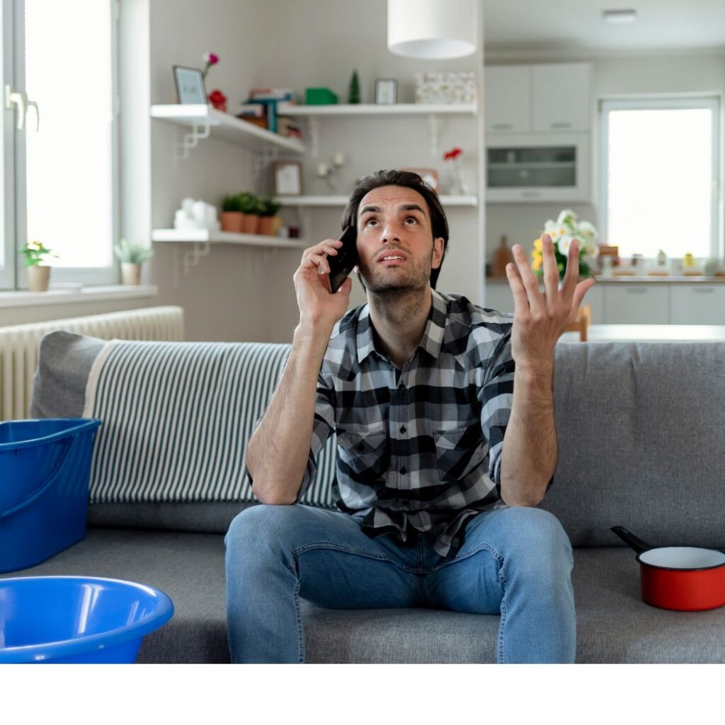an upset person on the phone with a leaking ceiling