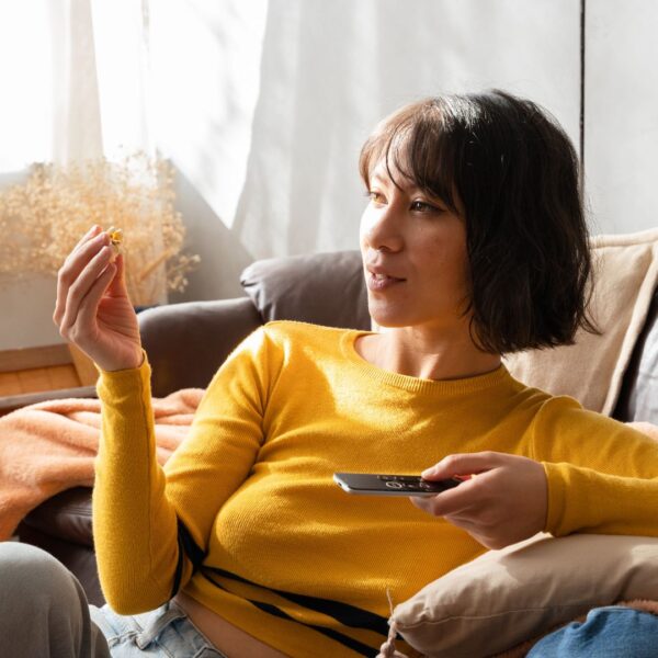 woman watching tv on her couch in the early evening.