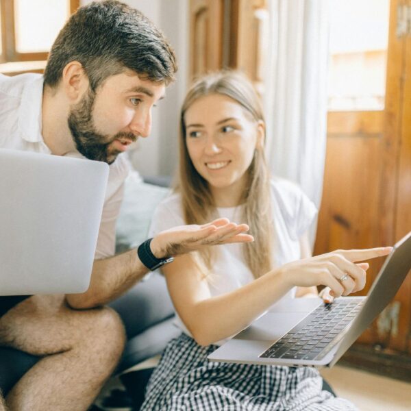 two people researching on laptops